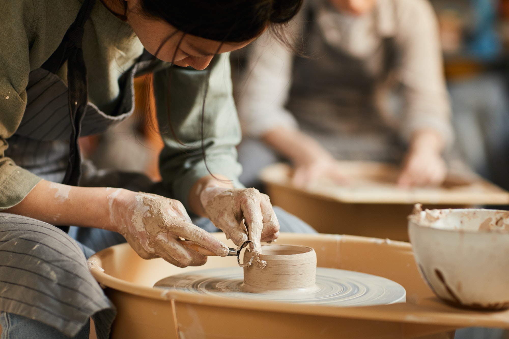 Shaping wet clay on pottery wheel
